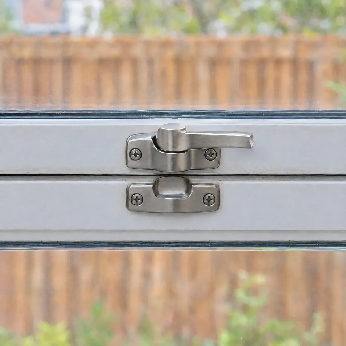 Close-up of a sash lock with its lever tip snapped off on a white meeting rail